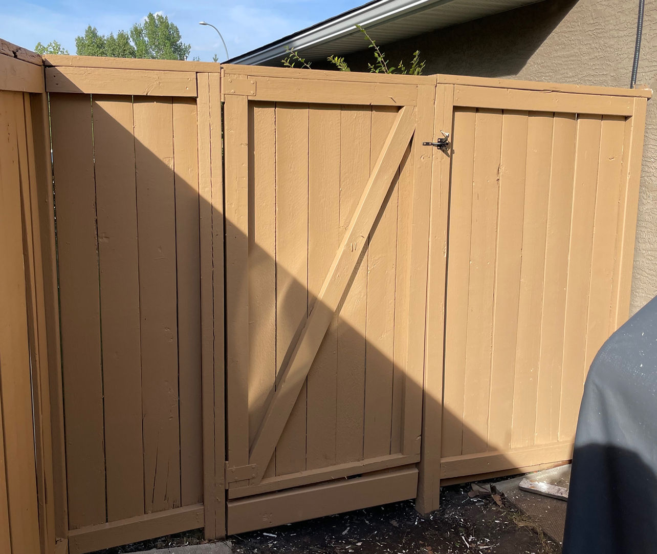 Same back gate restained in a warm cedar tone by B&R Painting Calgary